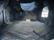 iKamper rooftop tent sleeping area on the 2025 Metalian Genie — ventilated windows and stowed ladder (view 7)
