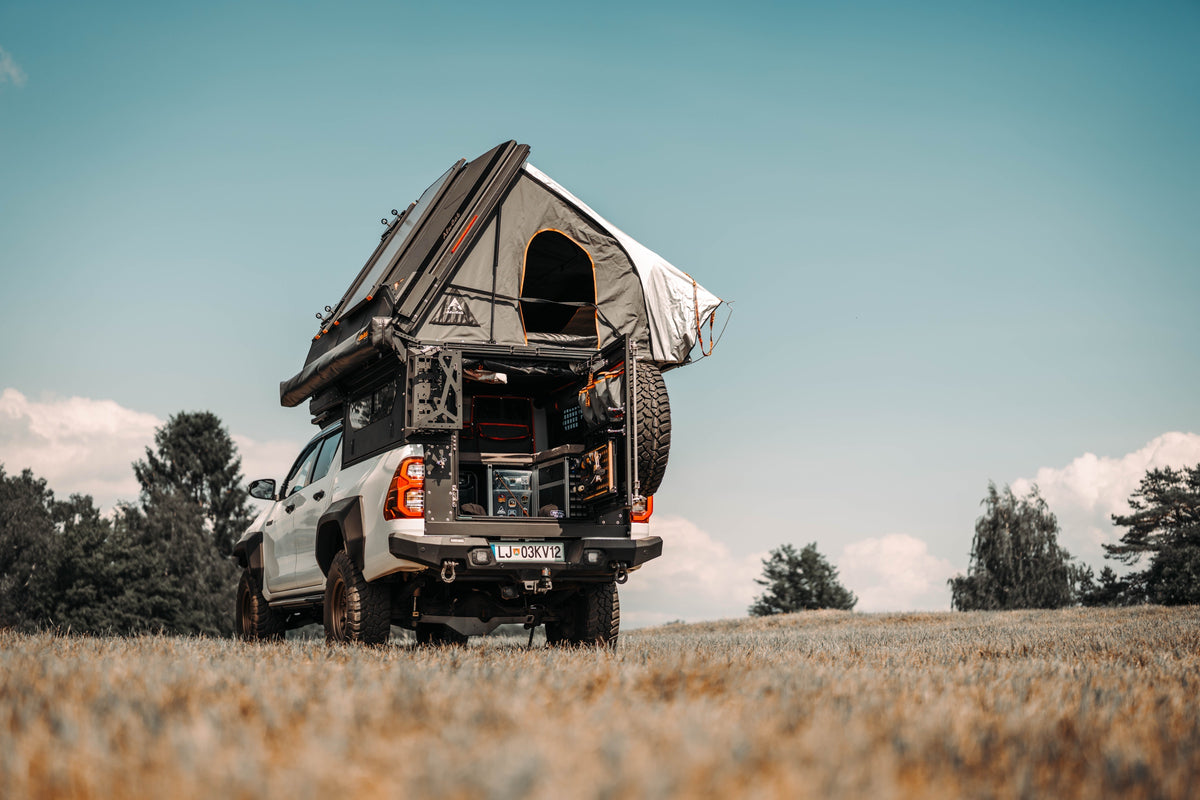 Alu-Cab ModCAP with Family 4-sleeper camper tent on a Toyota Hilux, rear door open