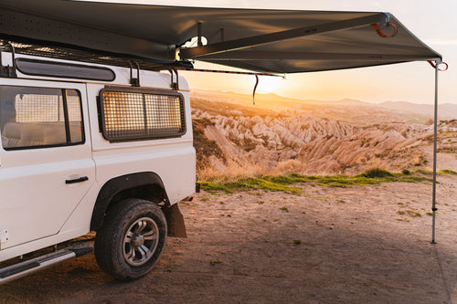 Alu-Cab 180 Shadow Awning open on a Land Rover Defender at a sunset cliff