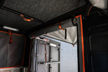 Alu-Cab rear mozzie net with privacy canvas rolled up, seen from inside the camper