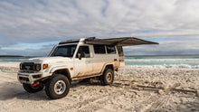 Alu-Cab Hercules white roof conversion with awning on a Land Cruiser 78 Troopy on the beach
