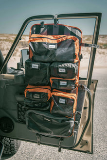 Alu-Cab Modular Fold-Up Duffle hung on a vehicle door, loaded with mesh packing bags