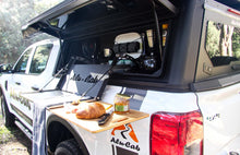Alu-Cab canopy fold-out kitchen table in use with bamboo cutting board