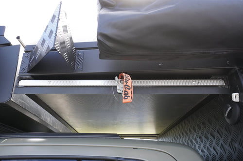 Alu-Cab table slide fitted under the Khaya canopy overhang, latch and strap closed