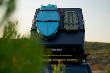 Surfboard and recovery boards strapped to the Alu-Cab LT-50 Molle plate