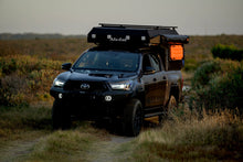Dark Toyota Hilux with Alu-Cab ModCAP and 2-sleeper Camper Tent at dusk