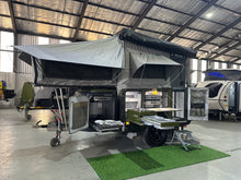 Invader Duo XS set up with roof popped, awning out and slide-out kitchen