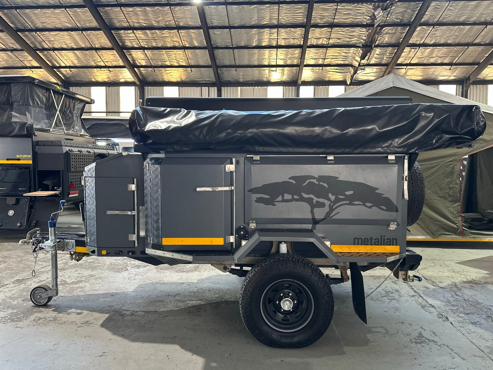 Metalian Maxi side profile in charcoal with the acacia graphic, spare wheel and off-road tyres