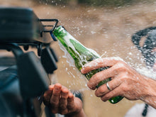 Rack mounted bottle opener in use