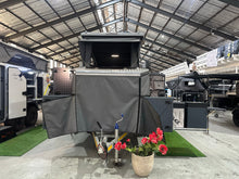 Silverback Lunar off-road camper, front view with the lift-up roof raised and the jockey wheel down