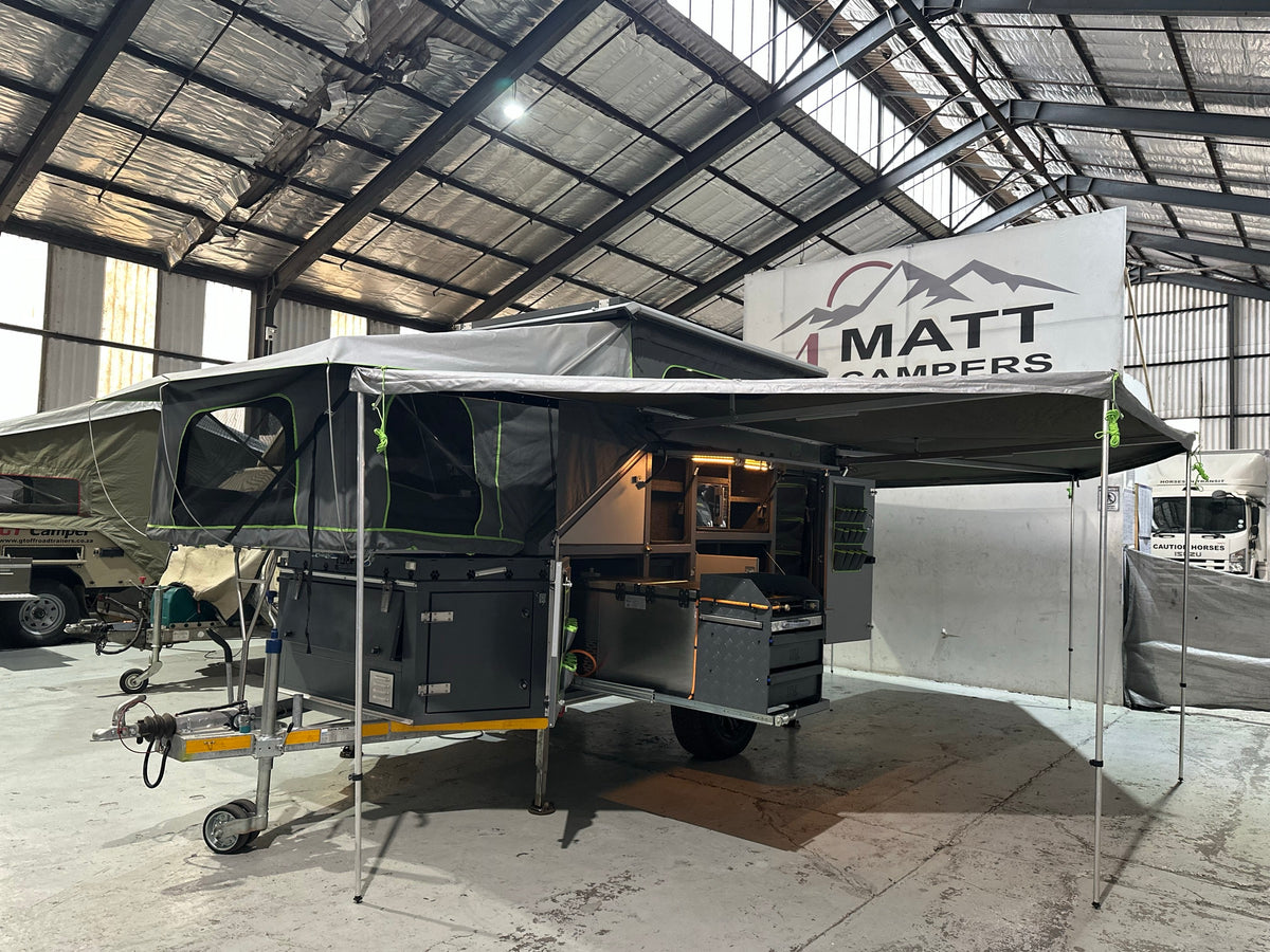 2025 Tuff Cats Shumba Elite 2 – front three-quarter view set up at camp with the 270° awning out and kitchen open